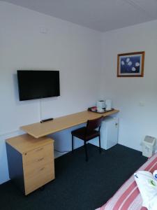 a room with a desk with a television and a bed at Mount Beauty Motor Inn in Mount Beauty