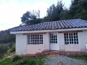 a small white building with a garage at Villa Paola del Lago in Cuítiva