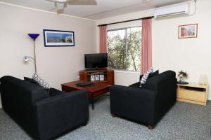 a living room with two couches and a television at Westwood Motor Inn in Armidale