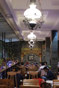 a group of people sitting at tables in a restaurant at Baratha Hotel & Resto in Bondowoso