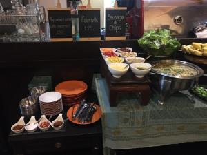 a buffet with bowls and plates of food on a counter at iuDia Hotel in Phra Nakhon Si Ayutthaya