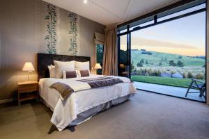 a bedroom with a large bed and a large window at Dunalistair House at The Kinloch Club Golf Course in Kinloch