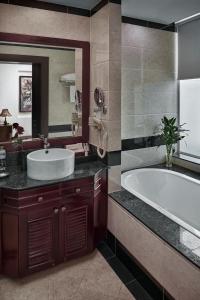 a bathroom with a tub and a sink and a mirror at Phnom Penh Katari Hotel in Phnom Penh