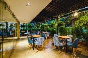 a restaurant with tables and chairs and plants at Ambar Hotel Boutique in Cali