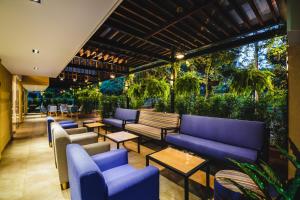 a patio with blue couches and tables and plants at Ambar Hotel Boutique in Cali