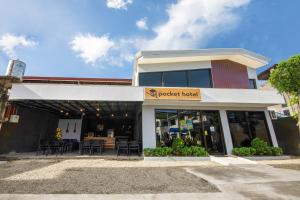 un negozio di fronte a un edificio con tavoli e sedie di The Pocket Hotel a Mactan