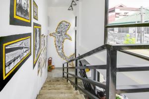 una scala in una casa con opere d'arte alle pareti di The Pocket Hotel a Mactan