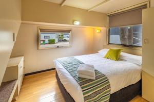 - une chambre avec un grand lit et une fenêtre dans l'établissement Ingenia Holidays Sydney Hills, à Dural