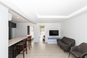 a kitchen and living room with a table and chairs at Christmas Island Apartments in Flying Fish Cove