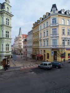a city street with cars parked in front of buildings at Apartman "Alika" in Karlovy Vary