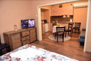 Habitación con cama y cocina con mesa de comedor. en City apartments en Varna