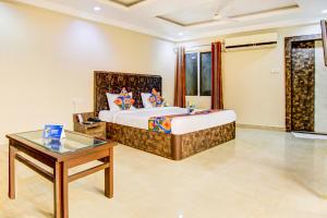Un dormitorio con una cama y una mesa en una habitación. en Via CT Palace, en Bhopal