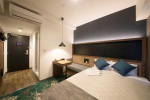 a bedroom with a large bed and a desk at Quintessa Hotel Fukuoka Tenjin Minami in Fukuoka