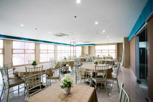 a dining room with tables and chairs and windows at Asrodel Hotel RedPartner in Davao City