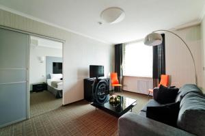a living room with a couch and a bedroom at Don Plaza Congress Hotel in Rostov on Don