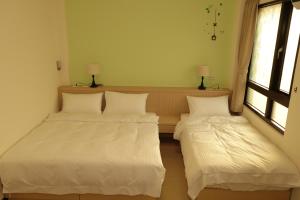 2 letti in una camera con 2 finestre di Le Ye B&B a Jinning