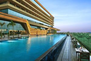 a swimming pool in front of a building at Gift City Club, a member of Radisson Individuals in Gandhinagar