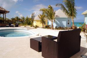a patio with a pool and chairs and a house at Paradise Bay Bahamas in Farmerʼs Hill