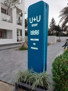 un panneau bleu devant un bâtiment dans l'établissement U+U Stay, à Magong