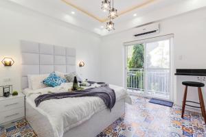 Un dormitorio blanco con una cama y una chimenea. en FRESIA by J&J Homes At Amani Grand Resort Residences Near Airport, en Mactan