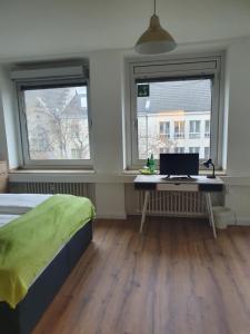 Schlafzimmer mit einem Bett und einem Schreibtisch mit einem Computer in der Unterkunft Studiotel TOP LOFT in Düsseldorf
