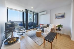 un soggiorno arredato con una grande finestra di Mega Style Apartments Opus a Melbourne