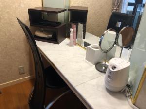 um balcão de casa de banho com um espelho e um lavatório em Restay Penthouse (Adult Only) em Kitakyushu