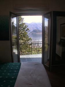 a bedroom with a door open to a view of the water at Villa Niccolò in Griante Cadenabbia
