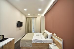 a bedroom with a bed with a tv on a wall at Bonjour Boutique Hotel Yerevan in Yerevan