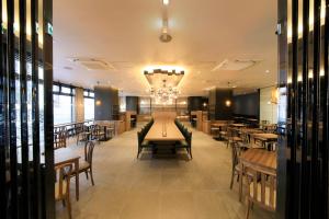 een restaurant met tafels en stoelen en een kroonluchter bij Quintessa Hotel Fukuoka Tenjin Minami in Fukuoka