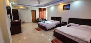 pokój hotelowy z 2 łóżkami i telewizorem w obiekcie Hotel Skypark, Sreemangal w mieście Sreemangal