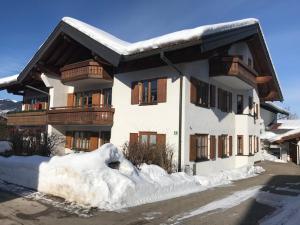 a building with snow on the ground in front of it at Große Wies in Oberstdorf