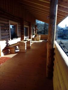 a porch of a log cabin with wooden floors and windows at Reiterhof Mühlbauer in Grattersdorf