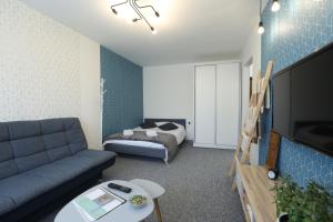 a living room with a couch and a bed at Delightful Apartment - FREE PARKING - NETFLIX in Kaunas