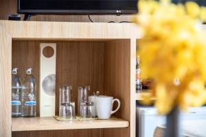 a shelf with glasses and a cup and a mug at Garden Cliff Resort And Spa in North Pattaya