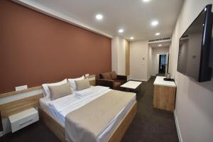 um quarto de hotel com uma cama e uma televisão de ecrã plano em Bonjour Boutique Hotel Yerevan em Yerevan