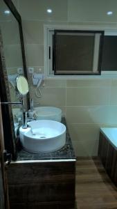 a bathroom with a white sink and a mirror at SAHA NOFY Ambohimalaza Guest in Antananarivo
