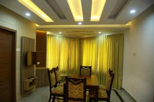 a dining room with a table and chairs and a television at KRISHNA HOLIDAY VILLAGE in Trichūr