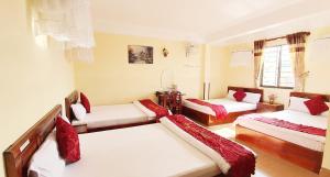 a room with three beds and a couch at Thanh Thao Dalat Hotel in Da Lat