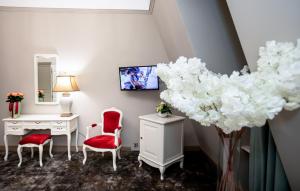 a room with a desk and chairs and a vase of flowers at Grand Hotel Traian in Iaşi