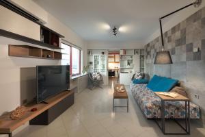 a living room with a couch and a tv at Stefan's Penthouse in Chania Town