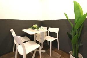 una mesa blanca con sillas blancas y una planta en EK1 Elizabeth Garden Kuromon en Osaka