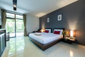 a bedroom with a large white bed with red pillows at The RiverKwai Bridge Resort in Kanchanaburi City