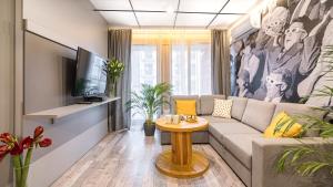 ein Wohnzimmer mit einem Sofa und einem TV in der Unterkunft Maya's Flats & Resorts 24 - Hollywood in Danzig