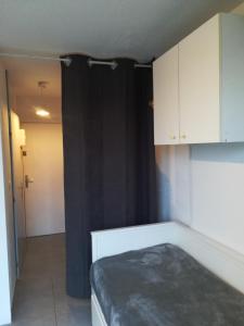 a room with a bed and a black curtain at Studio la grande motte, parking in La Grande-Motte