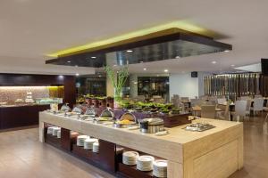 a buffet in a restaurant with food on display at Hotel Santika Bandung in Bandung