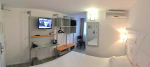 Cette chambre comprend un lit et une télévision murale. dans l'établissement Hotel du Parc Euromédecine by AKENA, à Montpellier