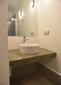 a bathroom with a white sink and a mirror at Lazuli Resort in San Vicente