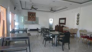 restauracja ze stołami i krzesłami w pokoju w obiekcie Liberty Homestay w mieście Parit