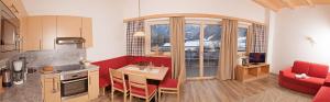 a kitchen with a table and a red couch at Alpen-Apart in Schwendau